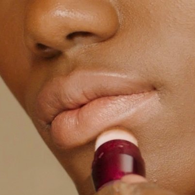 Woman applying Instant Age Rewind underneath lips
